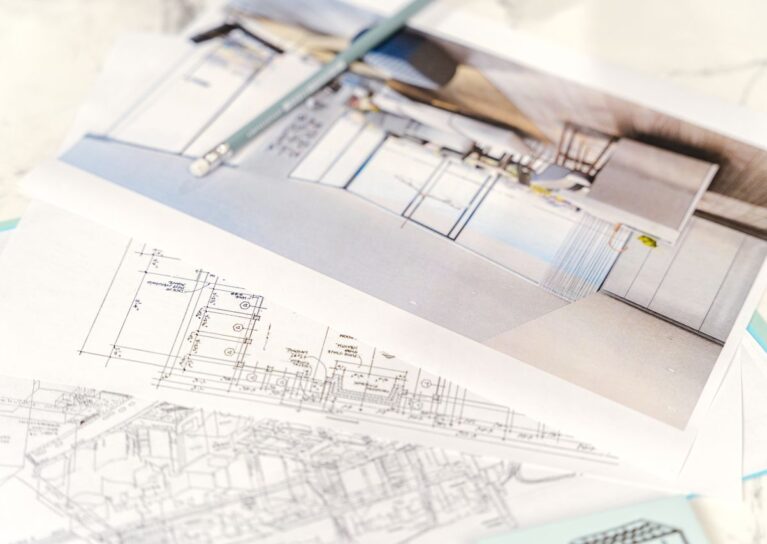 Close-up of architectural blueprints and 3D design on paper with pencil on a desk.