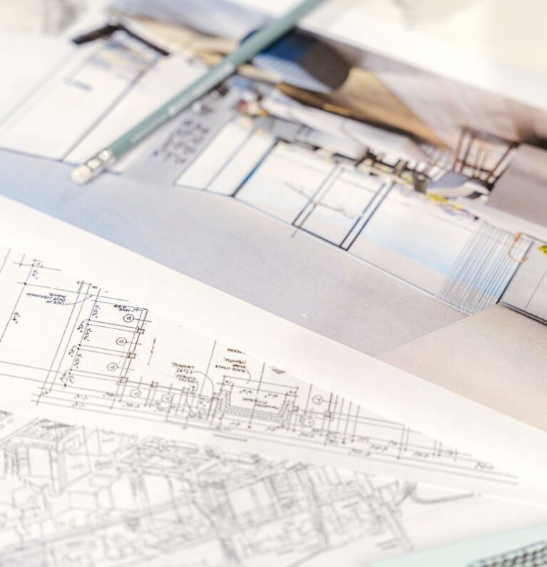 Close-up of architectural blueprints and 3D design on paper with pencil on a desk.