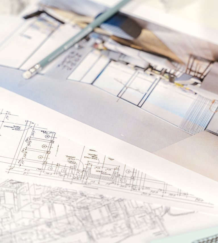 Close-up of architectural blueprints and 3D design on paper with pencil on a desk.